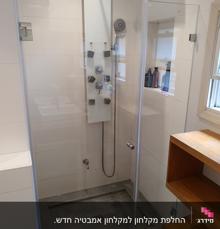 מקלחת עם ראש גשם ומדף עם בקבוקים